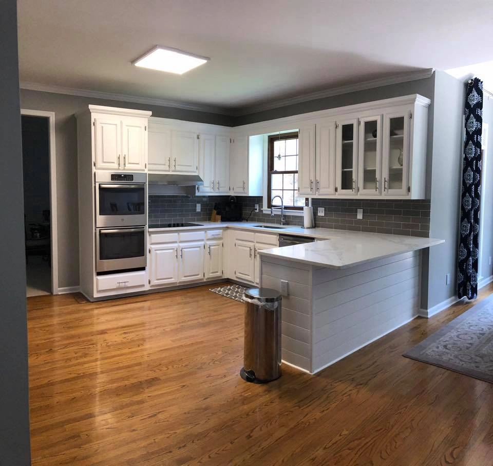 Renovated white kitchen with dark granite countertops