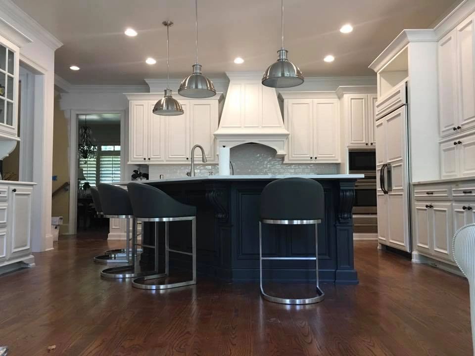 White kitchen with contrasting dark island and pendant lighting